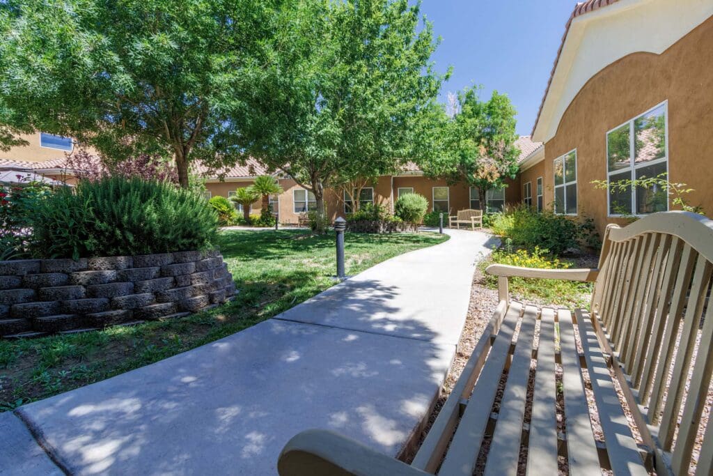 View from a bench looking at the beautiful courtyard with many trees and greenery at Vista Pointe at Mira Loma.