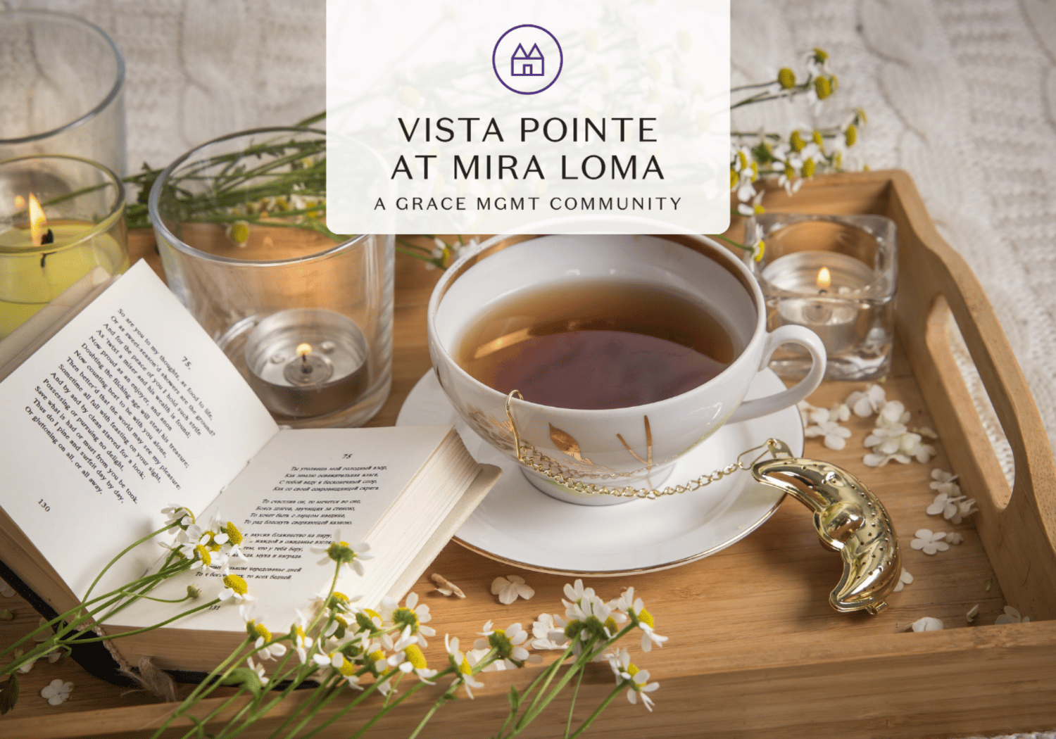 Cozy tea scene on a wooden tray with a teacup, open book, daisies, and candles, featuring the 'Vista Pointe at Mira Loma' branding.